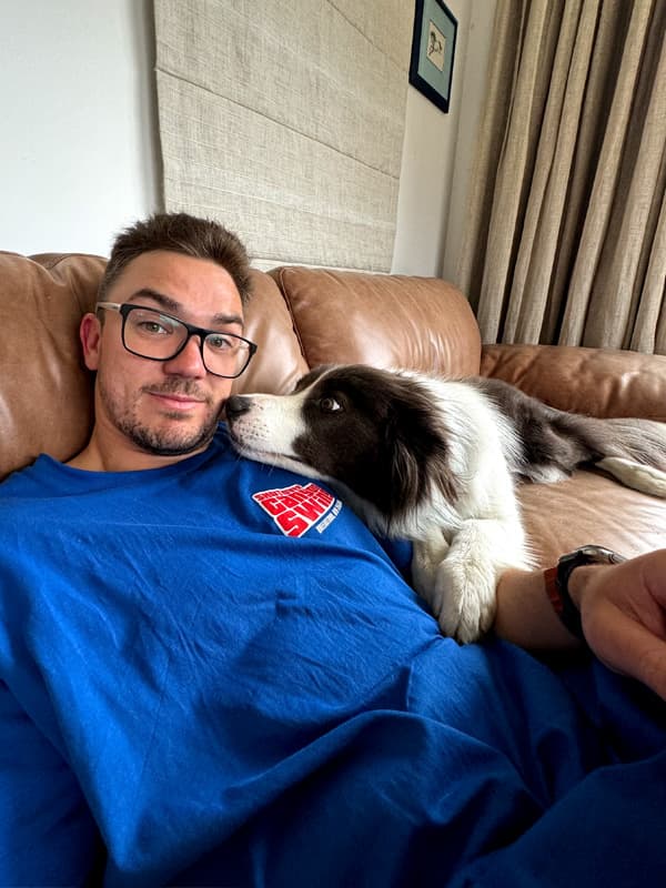 Man and collie dog laying on the couch